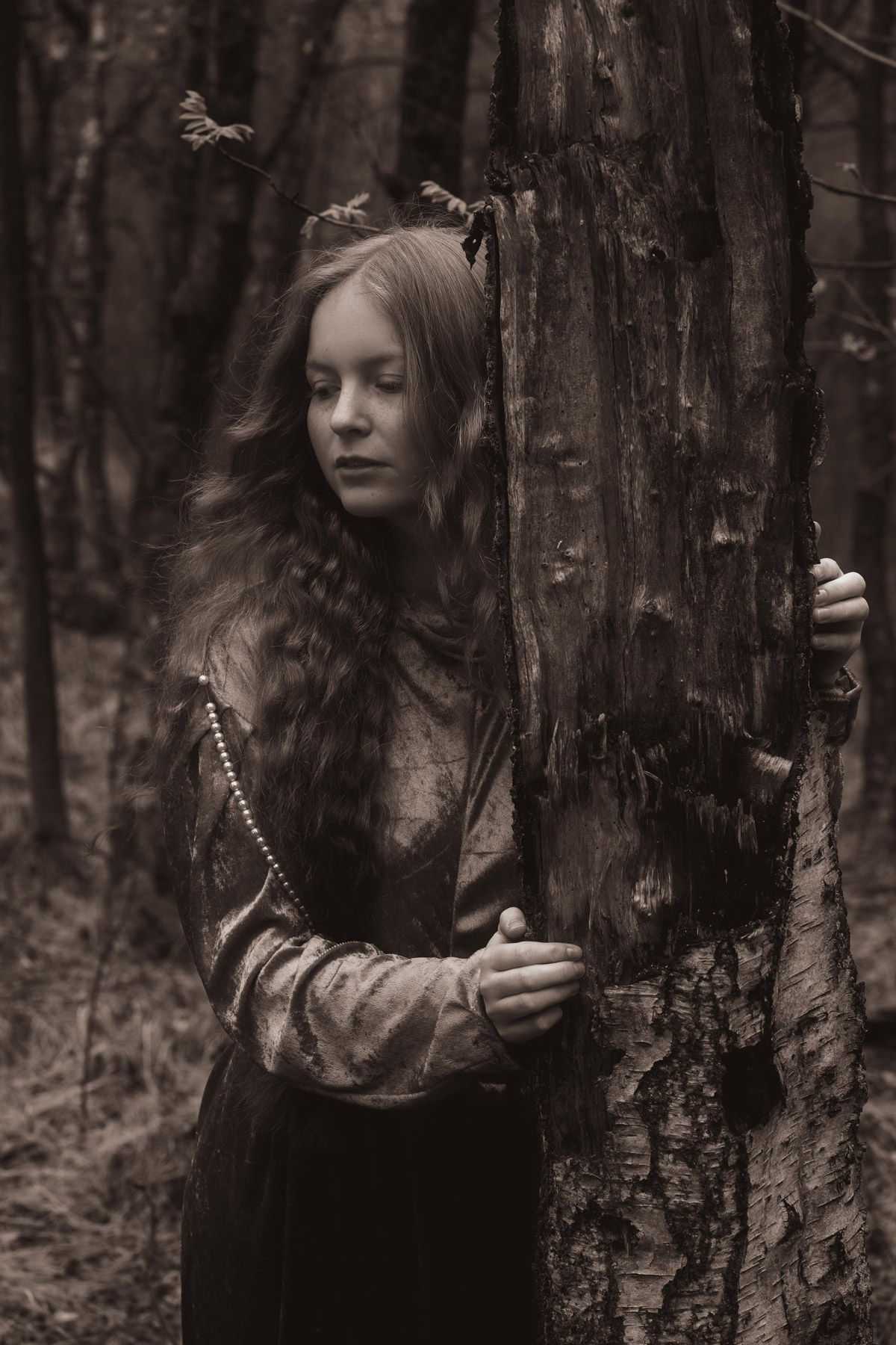 Junge Frau hält sich an einem Baumstamm fest. Fotograf: Lea Kutschke, Geraldine Kutschke / TWIINZ.