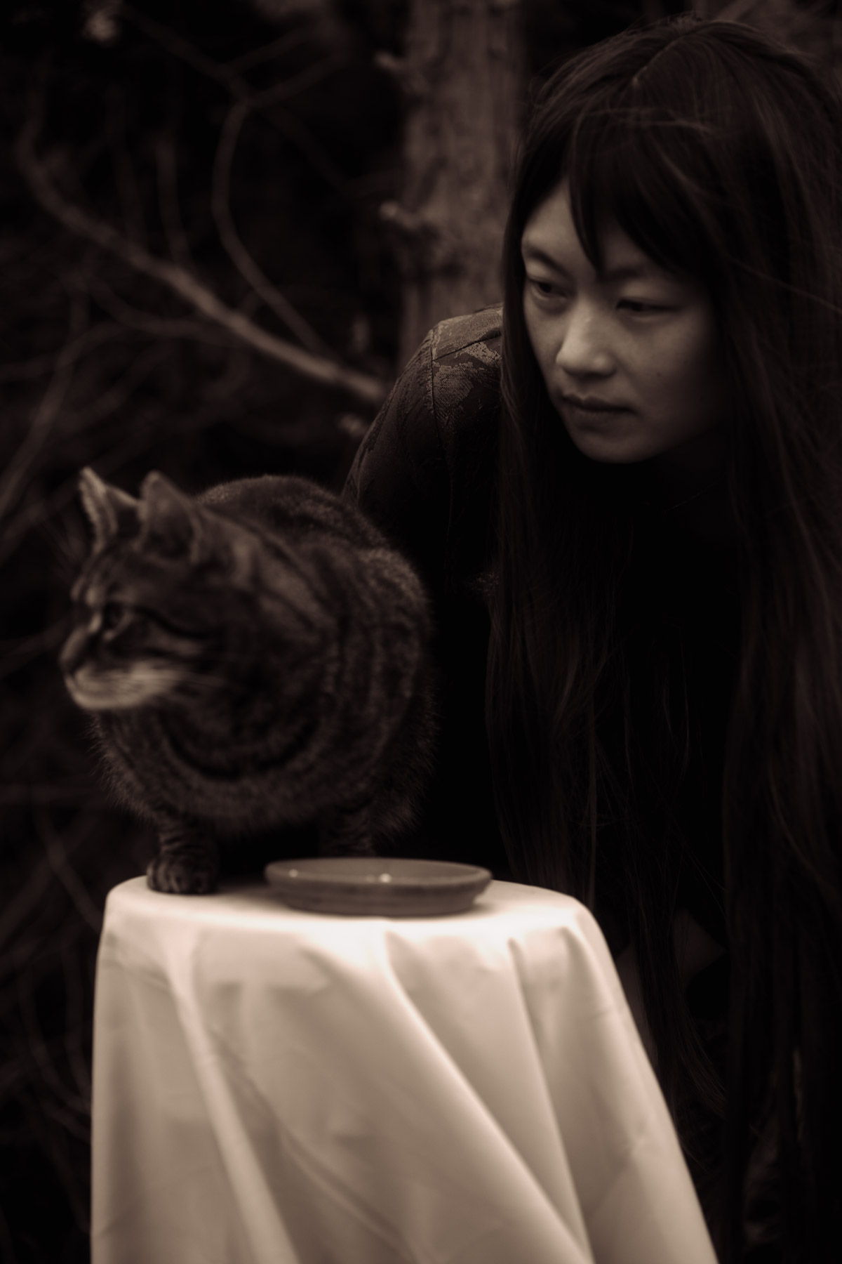 Frau betrachtet eine Katze auf dem Tisch. Fotograf: Lea Kutschke, Geraldine Kutschke / TWIINZ.